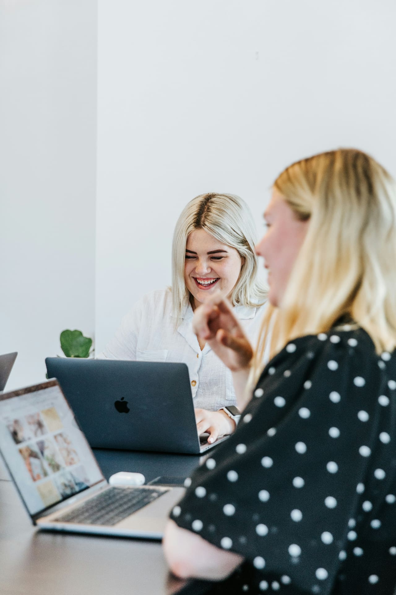 Two founders collaborating on laptops in a bright office — founder-led social media agency