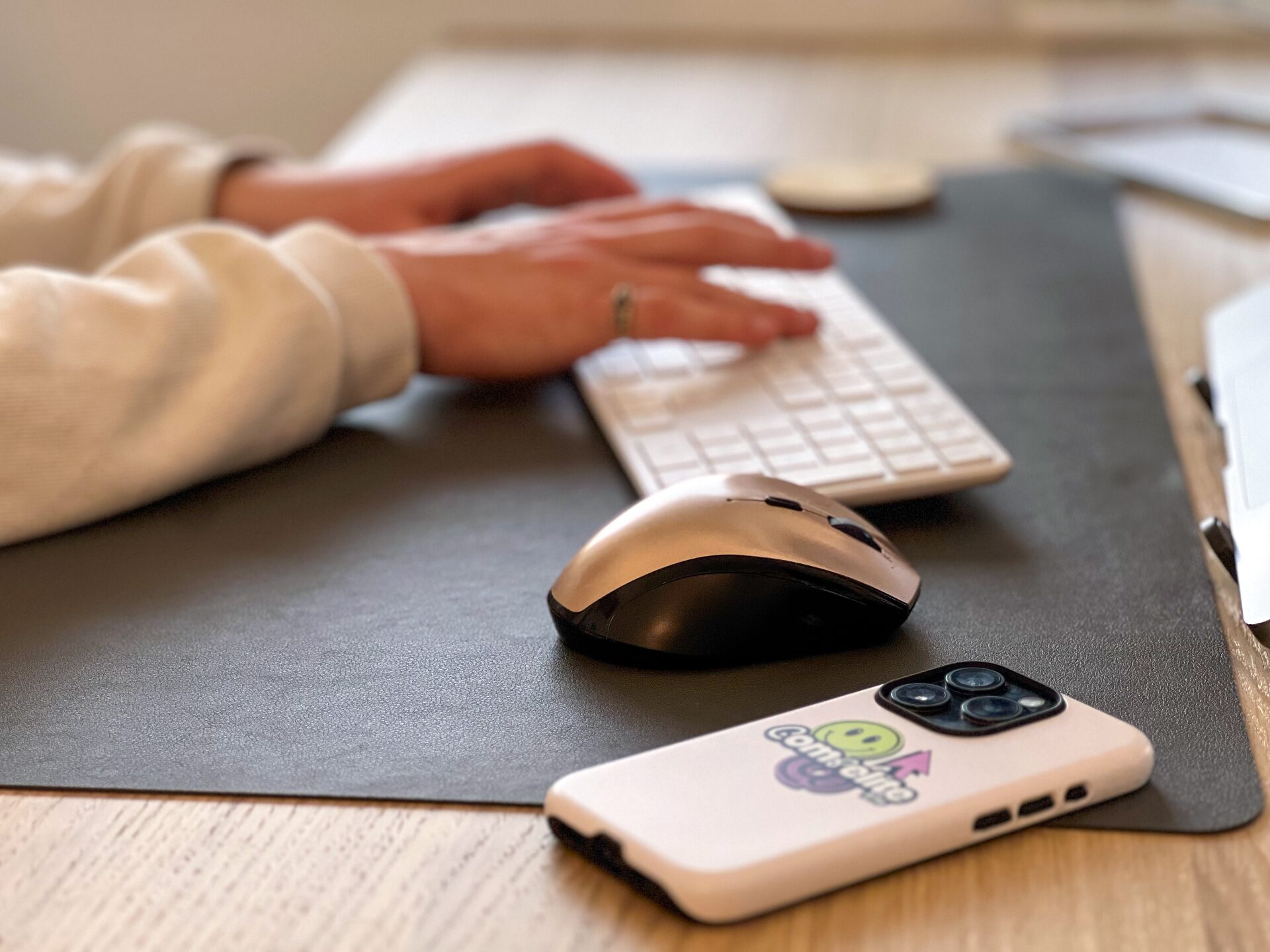Compelite Pro team member working at a desk with a Compelite Pro branded phone — focused on growth and sales
